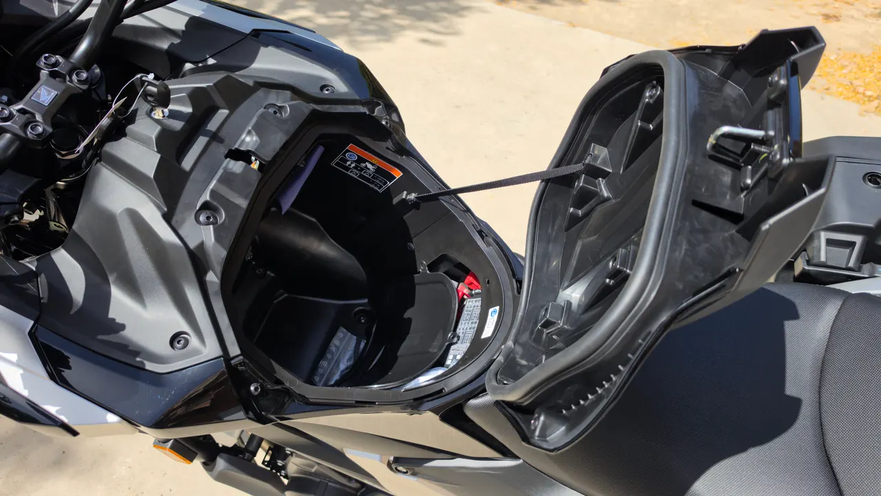 Compartimento de almacenamiento frontal abierto de la Honda NC750X donde cabe un casco integral