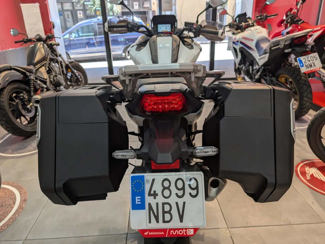 Vista trasera de una Honda Honda NC750X blanca con maletas laterales negras.