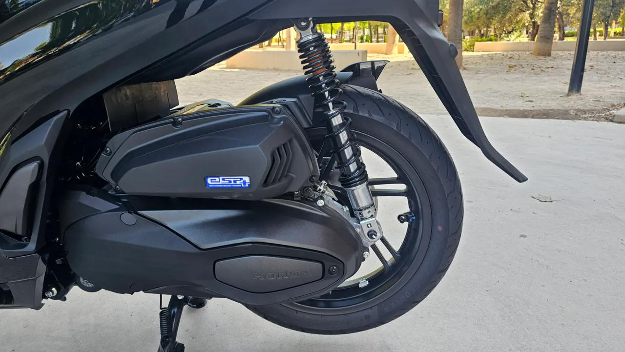 Detalle de la rueda trasera y motor de una Honda SH350i negra