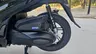 Detalle de la rueda trasera y motor de una Honda SH350i negra