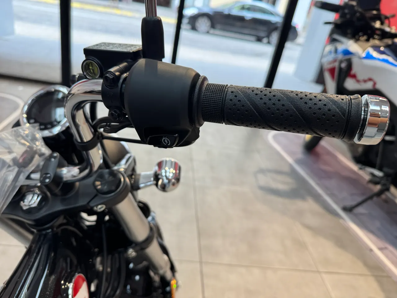 Manillar izquierdo de Honda Dax 125 negro con puño texturizado y detalles cromados.