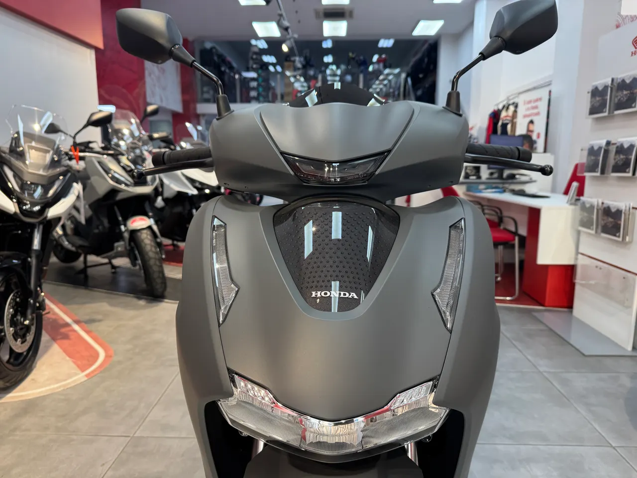 Vista frontal de una moto Honda SH 350i en color gris rock mate NH-C70.