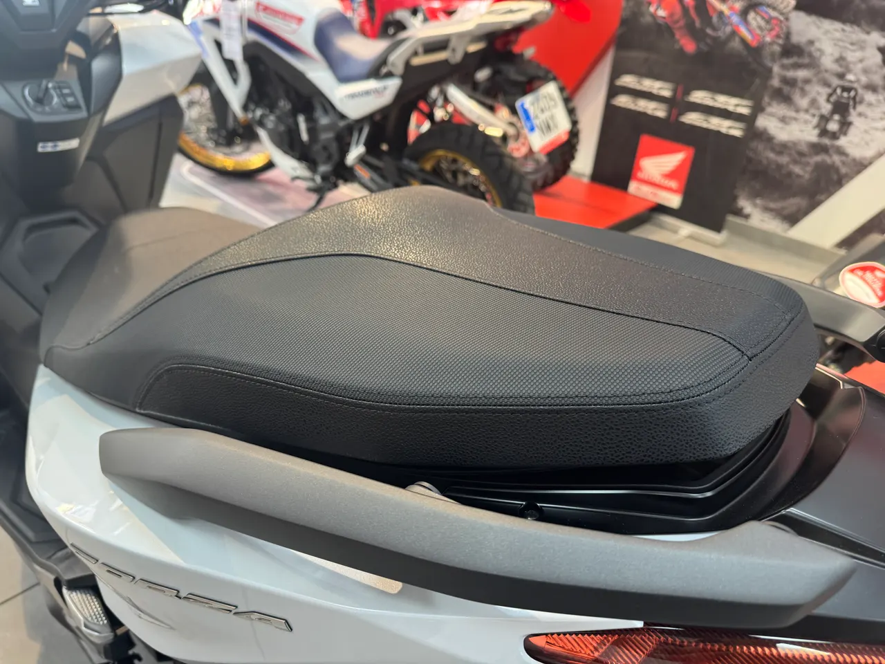 Asiento negro y parte trasera blanca de una Honda Forza 125