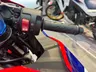 Detalle del manillar de una moto Honda CBR 600RR roja con el botón de arranque.