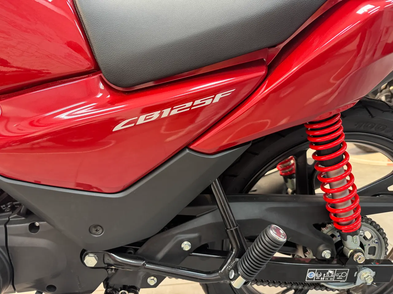 Detalle lateral de moto Honda CB125F color rojo