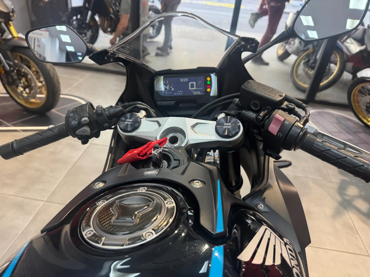 Vista del manillar, pantalla digital y depósito de una moto Honda CBR negra con detalles azules.