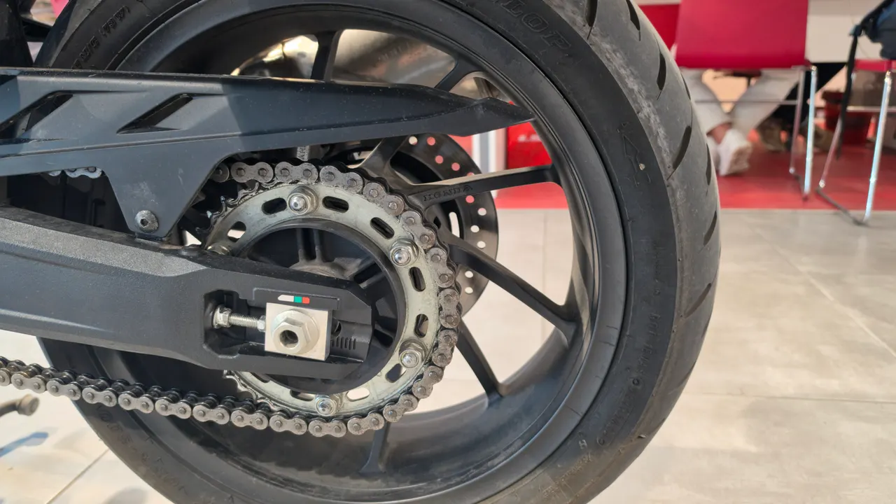 Detalle de la cadena, piñón y rueda trasera de una moto Honda NT1100