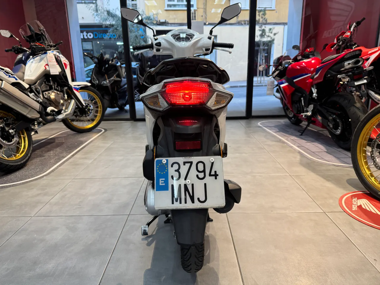 Vista trasera de una moto Honda Vision 110 blanca