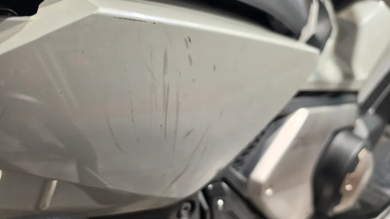 Detalle de rasguños en el carenado lateral de una moto Honda X-adv