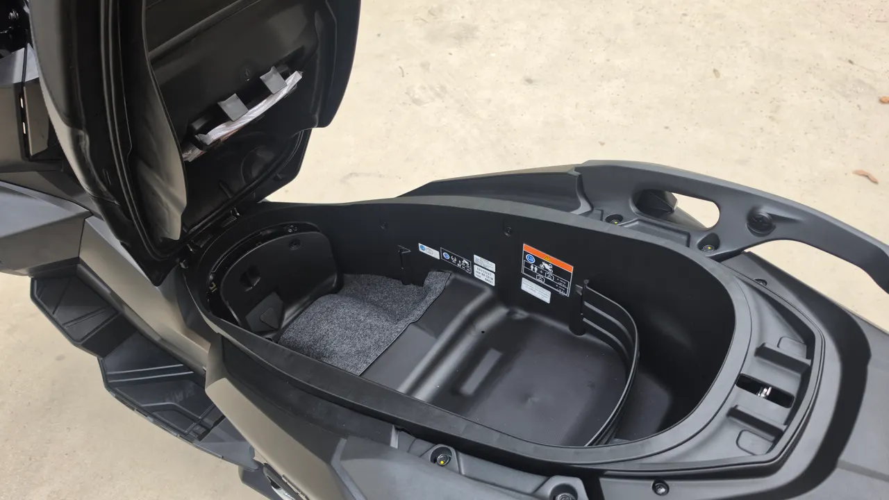 Compartimento de almacenamiento abierto de una Honda ADV 350 negra