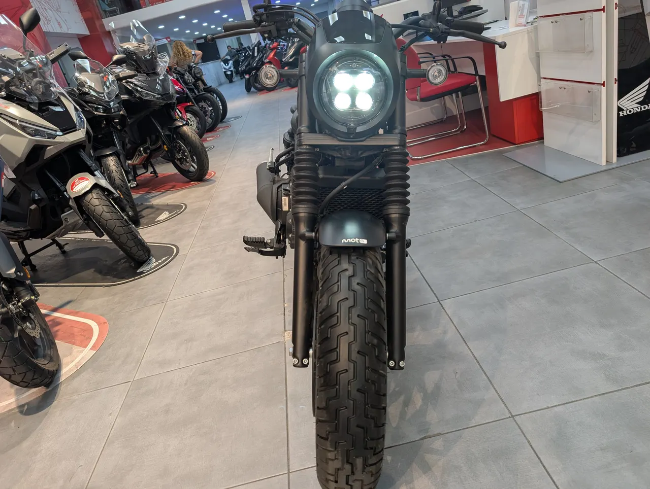Vista frontal de una moto Honda Rebel 500 de ocasion con faro LED redondo y neumáticos anchos.