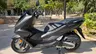 Scooter Honda PCX 125 negro mate aparcada en un parque
