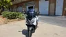 Honda Forza 125 blanca estacionada frente a concesionario Honda
