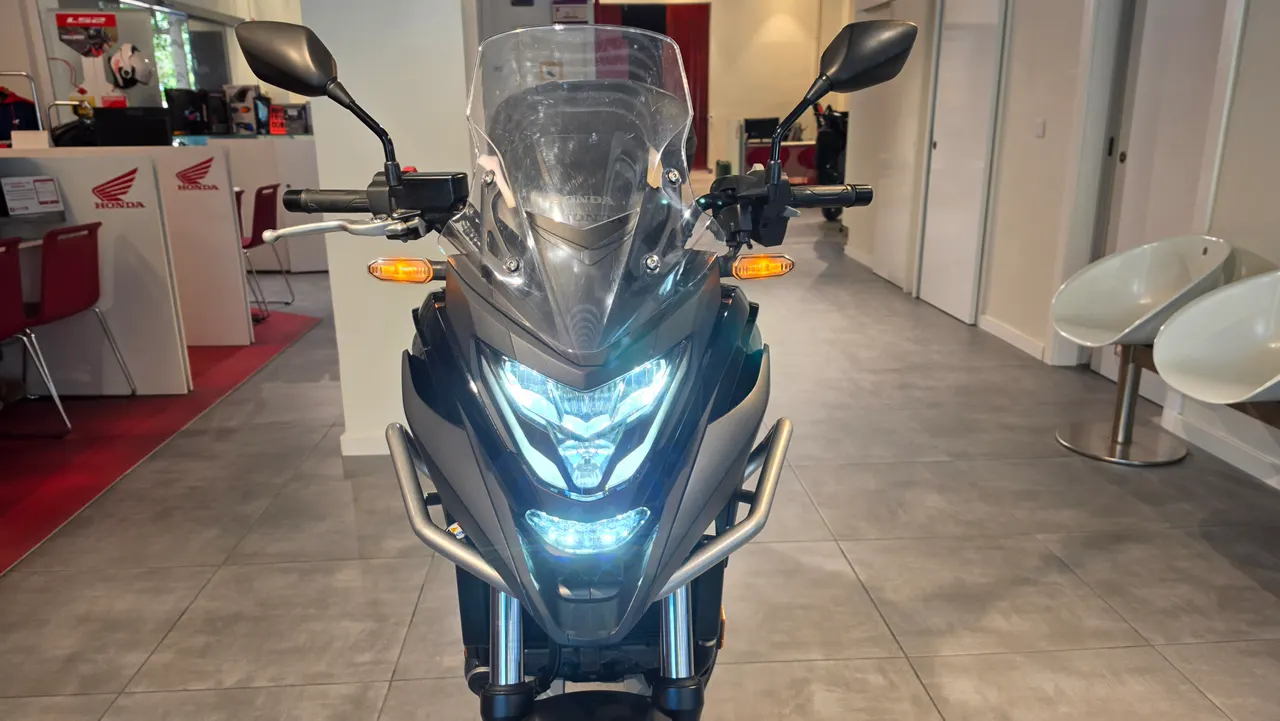 Vista frontal de una moto Honda NC750X de ocasion con luces encendidas