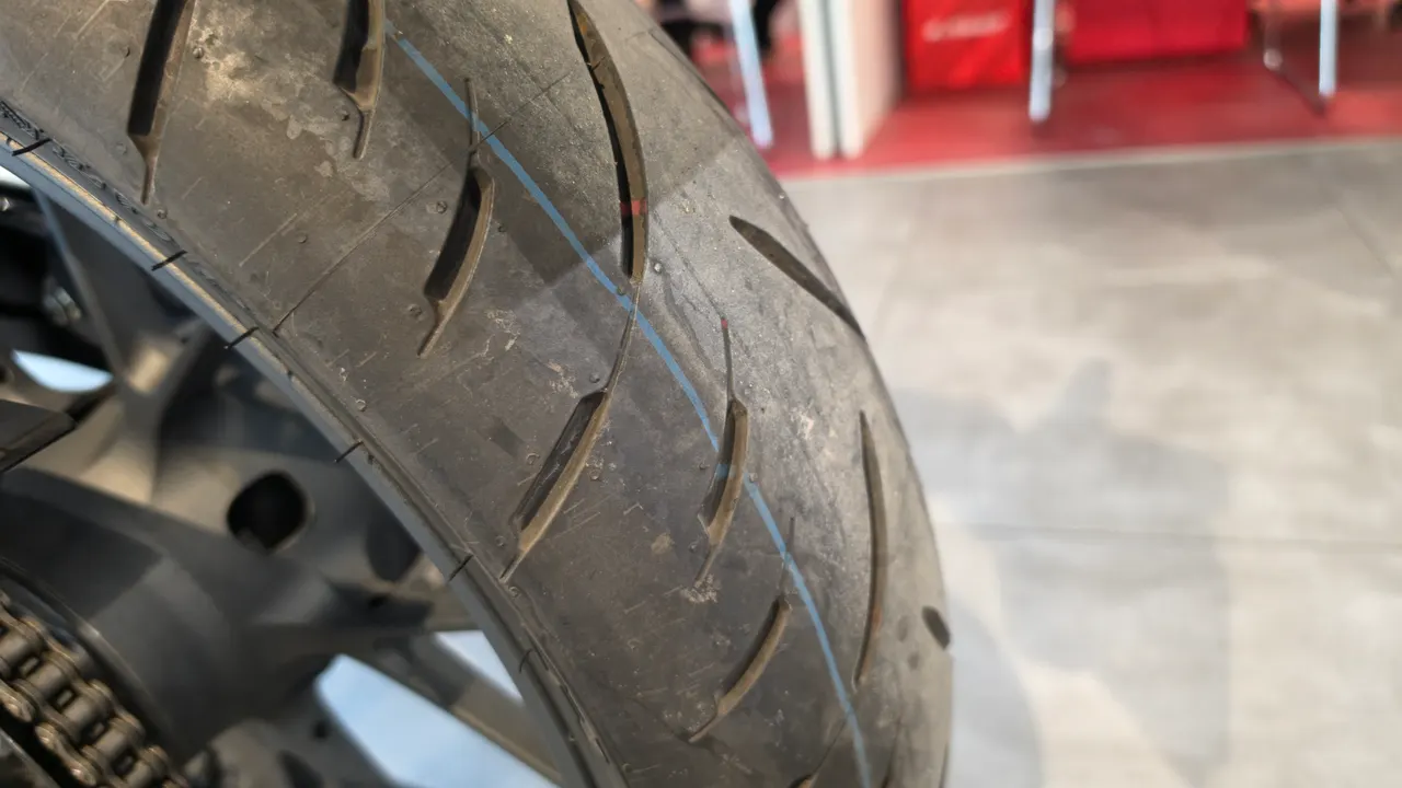 Primer plano de la rueda trasera de una moto Honda CB125R
