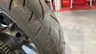 Primer plano de la rueda trasera de una moto Honda CB125R