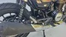 Detalle de la rueda trasera, amortiguador y escape de una Honda GB350S azul.
