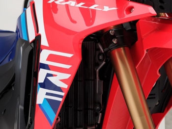 lateral derecho CRF300 Rally 2025 con sus nuevos adhesivos blancos y azules a contraste con el deposito de gasolina y cubre motor que son negros